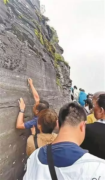 游客在梵净山景区岩壁上刻字 当地警方和