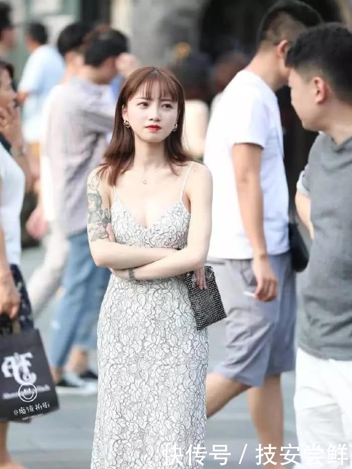 街拍:小姐姐身穿一条白色印花吊带裙,性感中带着一丝文艺小清新