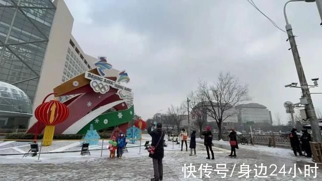 城市环境|雪花纷飞市民与冬奥花坛合影