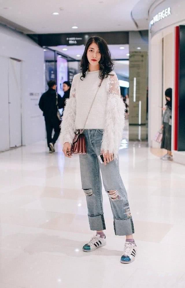 街拍时尚大气的美女,简洁的吊带背心搭配牛仔裤,显得十分修身立体