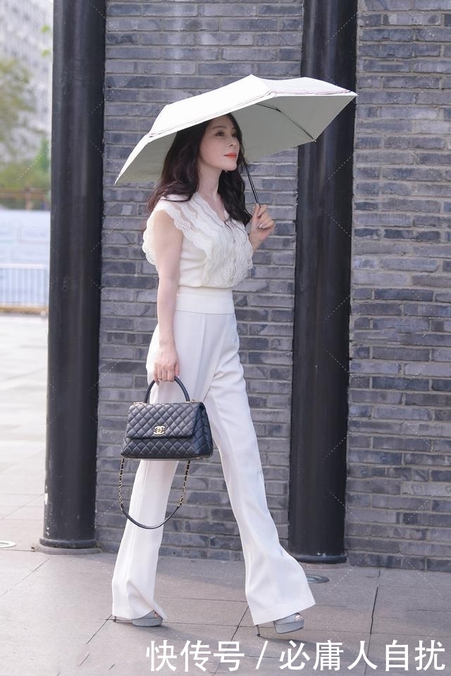 姑娘搭配一款深色的印花小衫,优雅大气