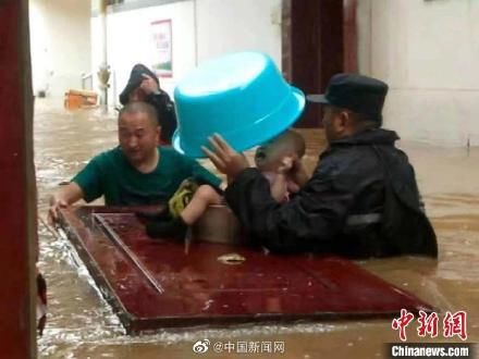 山西|山西晋城暴雨中民警以盆作伞转移被困小孩