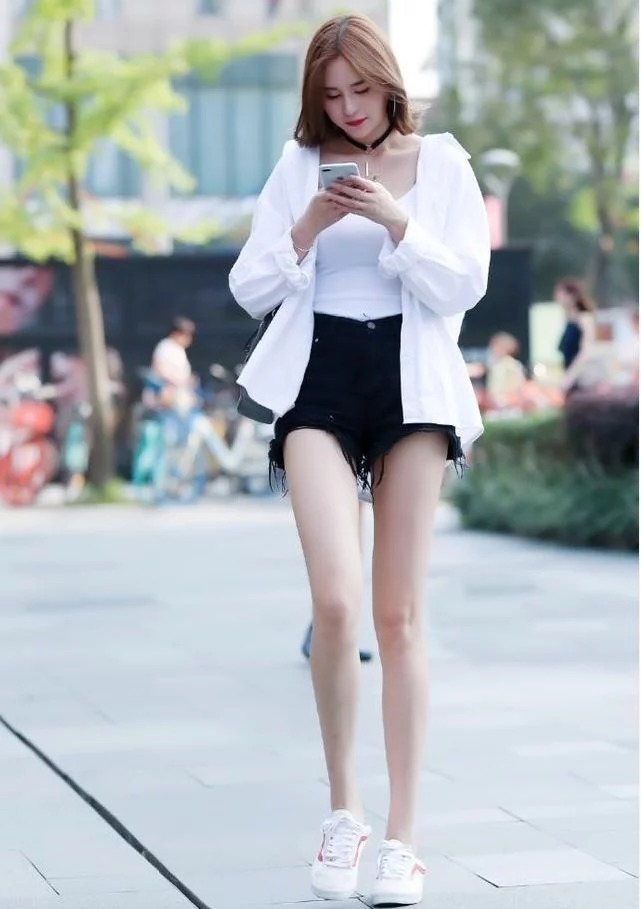 街拍：小姐姐身穿黑色吊带连衣裙，修长的美腿让人羡慕不已