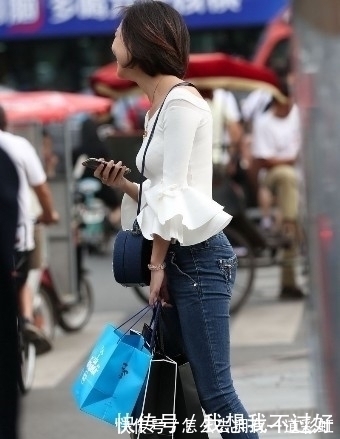 街拍|街拍:紧身牛仔裤搭配白色露肩装的美女,甜美笑容让人印象深刻