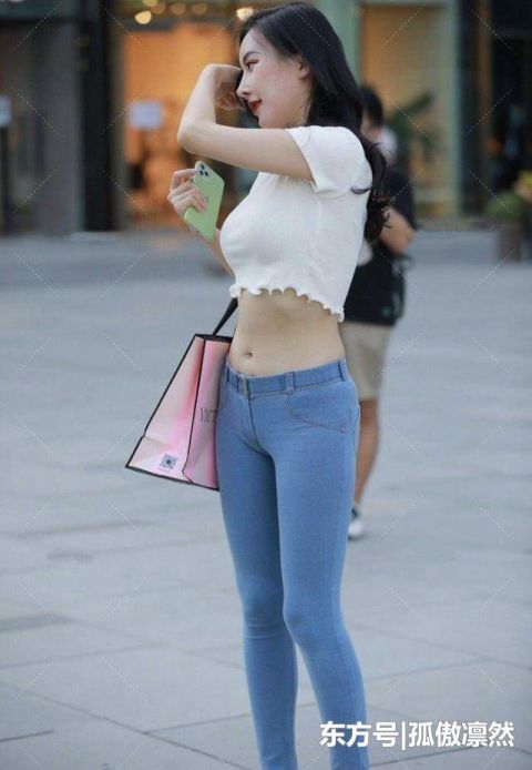 牛仔裤 美女白色上衣肚脐装搭配浅蓝色牛仔裤,增加了穿搭的创意和时尚感