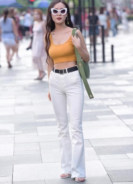 土黄色上衣搭配白色喇叭裤,既显腿长又能释放出女神的气质