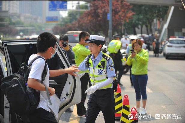 高考|高考考点外，女交警烈日下护送考生入场