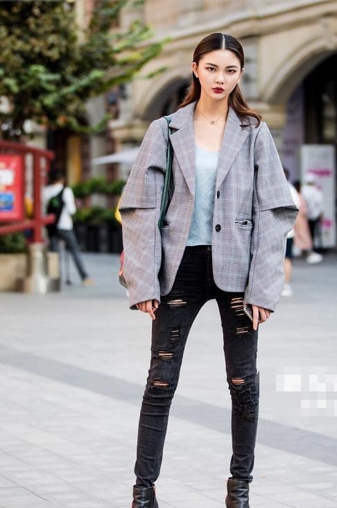 破洞牛仔裤 破洞牛仔裤搭配黑色皮质短靴,时尚靓丽,酷飒有型