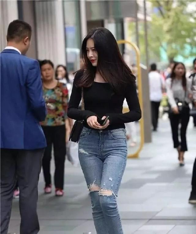 穿着|街拍:身材苗条的小姐姐,穿着黑色牛仔裤,显得有街头风的感觉