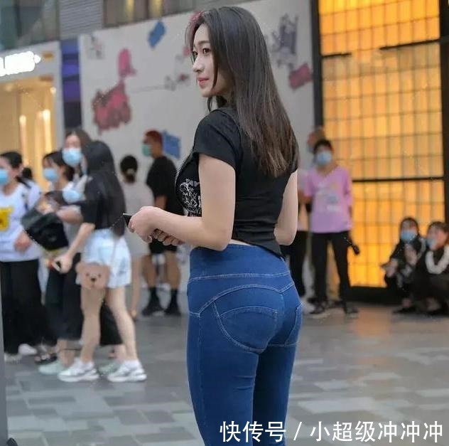 穿着 黑色露腰T恤，搭配蓝色牛仔裤，微胖妹妹必备！