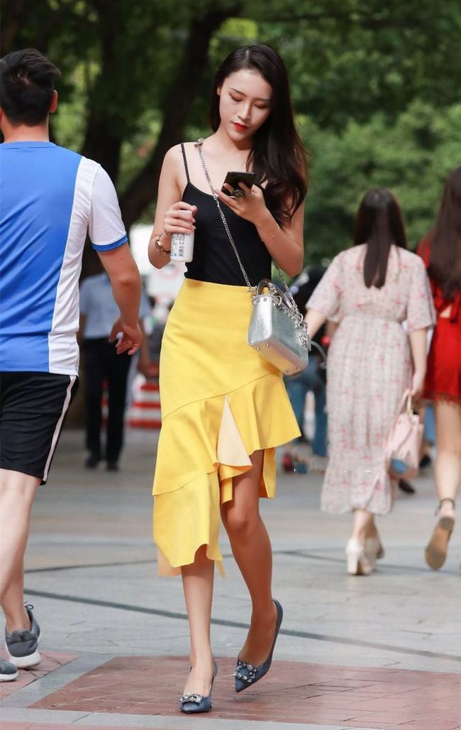 街拍美女：黑吊带衫搭黄色鱼尾裙，脚踩高跟鞋，色彩搭配恰到好处