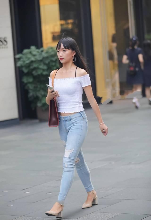 街拍|街拍美女破洞紧身牛仔裤搭配白色漏肩针织衫,很素雅的小姐姐
