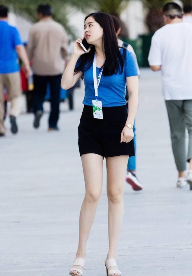 短袖|街拍黑色休闲短裤搭配蓝色短袖T恤,小姐姐打电话的姿势要优雅