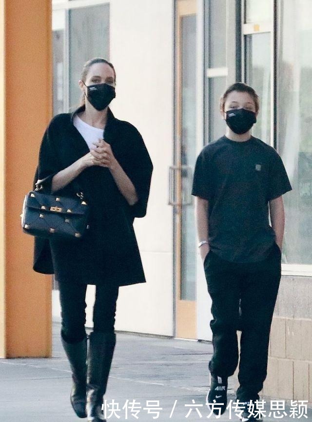 安吉丽娜·朱莉穿黑色斗篷上衣搭配细腿裤,和儿子逛街,真潇洒