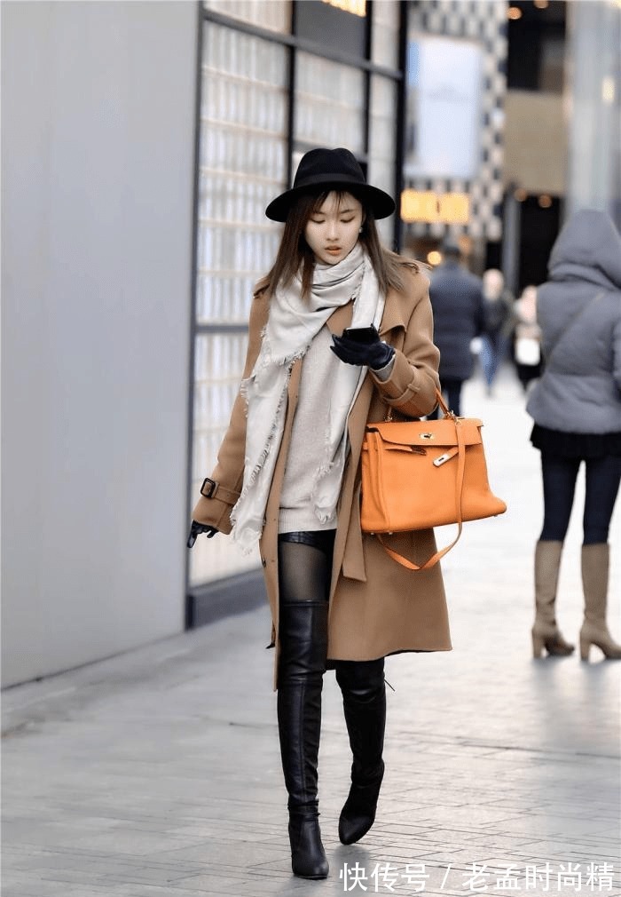 身材高挑 棕色呢子大衣,搭配黑色过膝皮靴,粗跟款式,衬托身材
