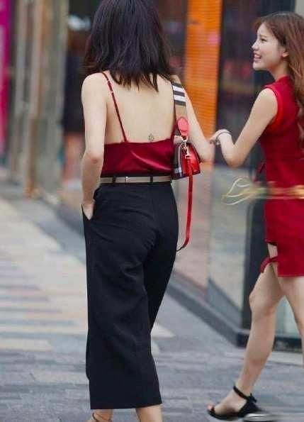街拍小姐姐身穿红色吊带背心性感娇艳,搭配休闲裤帅气又随性