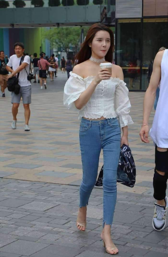 展现|街拍:美女穿着白色的抹胸上衣搭配牛仔裤,美腿曲线完美的展现!