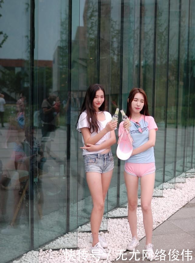 街拍:两个小姐姐喝汽水一起逛街,这对闺蜜哪个搭配得更好?