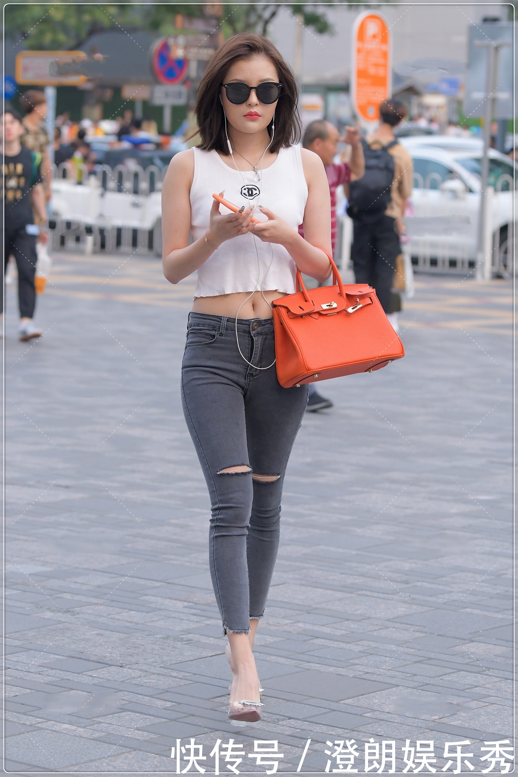 街拍美女简单的白色背心,搭配露膝牛仔裤很时髦,简约时尚