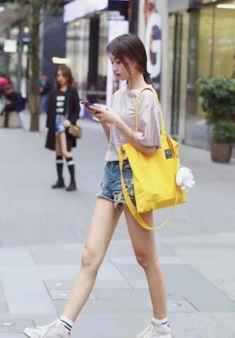 街拍：美女身穿白色抹胸上衣，身材高挑，一双大长腿吸睛无数