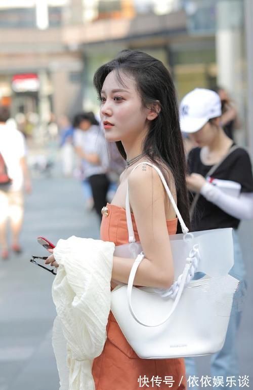 美女 人不仅长得漂亮，穿搭也很有个性，撩头发的侧脸很吸引人