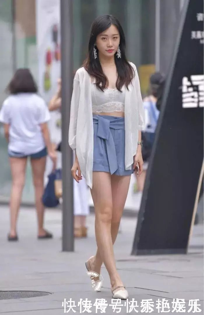 街拍时尚姑娘身穿白色内衬衣，笑容自信迷人