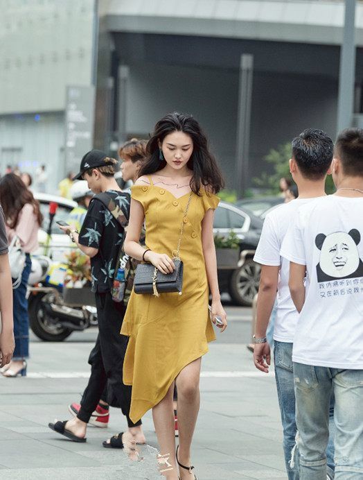 街拍小姐姐身穿黄色连衣裙,黄色很亮眼,走在街上很吸睛