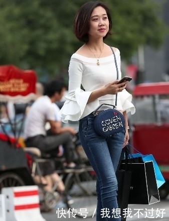 笑容|街拍:紧身牛仔裤搭配白色露肩装的美女,甜美笑容让人印象深刻