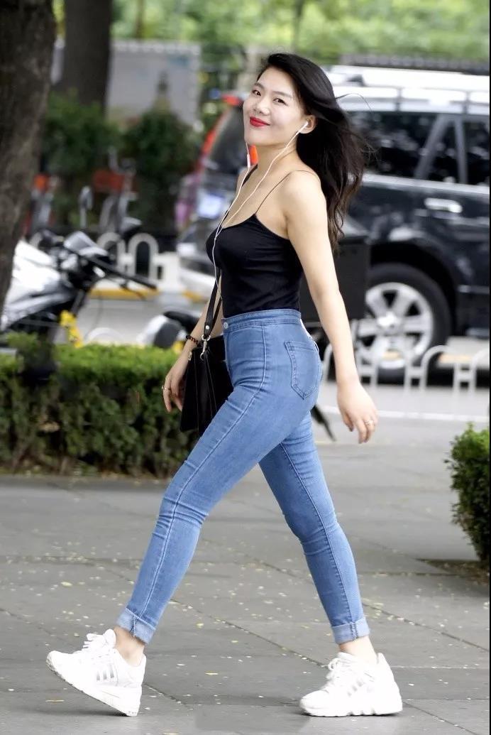 吊带|街拍黑色吊带背心搭紧身牛仔裤的性感姑娘,大方洒脱的气质
