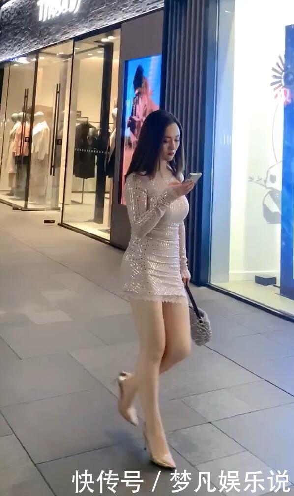 打扮精致的街头美女,泛光短裙配尖嘴高跟,时尚有个性