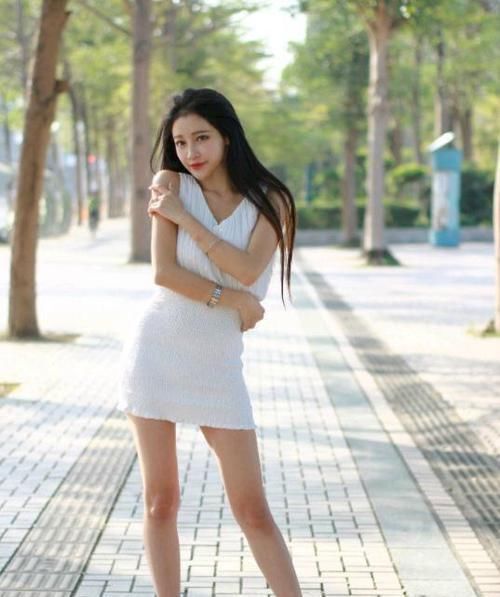 身穿|街拍小姐姐身穿喇叭一字肩上衣搭配浅蓝色牛仔热裤,美丽动人