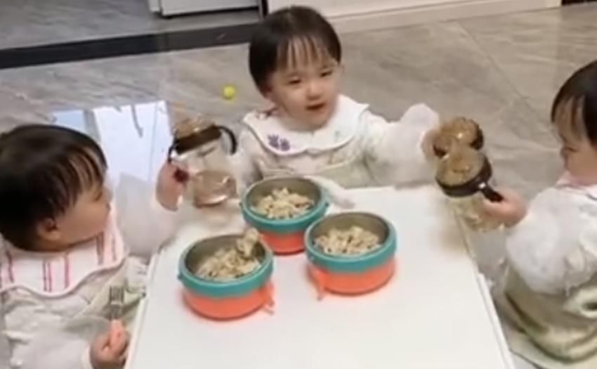 家长们|三胞胎吃饭时一个“碰杯”的举动萌翻众人,网友:军事化管理的好