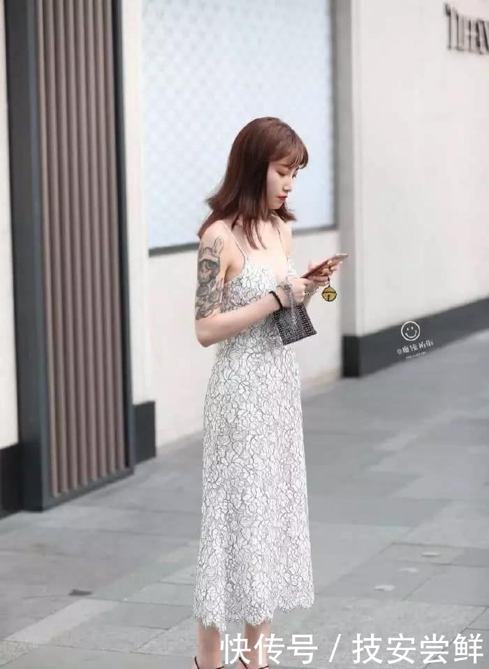 街拍:小姐姐身穿一条白色印花吊带裙,性感中带着一丝文艺小清新