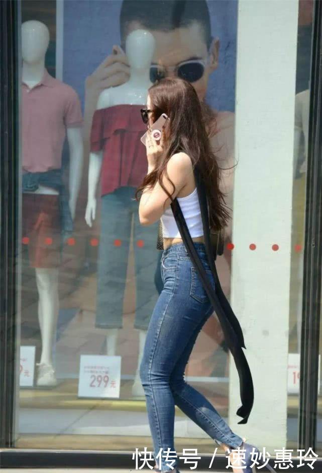 牛仔裤搭配白色吊装上衣,让你的美焕发光彩