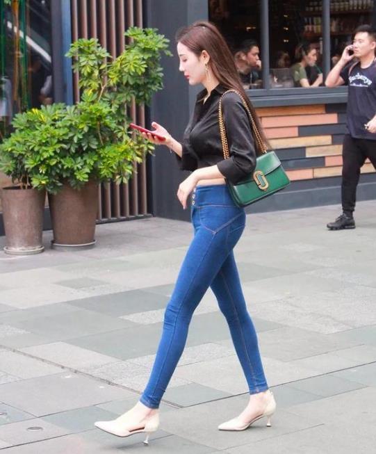 街拍丰标不凡的美女,白色短袖配黑色长裤,女神范十足