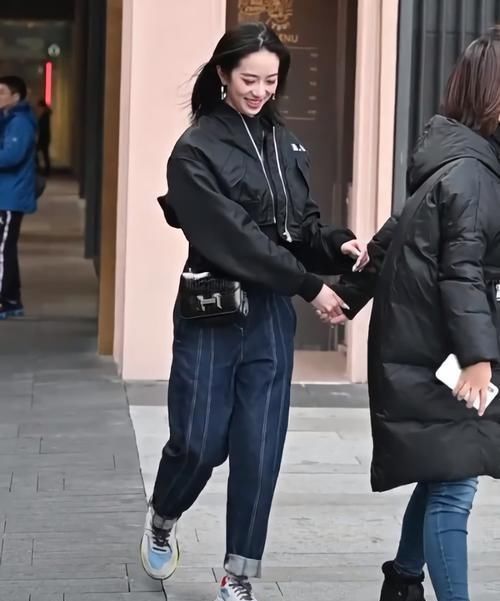 街拍美女黑衣蓝裤的小姐姐好帅气，抬脚就被“猫印鞋”抢镜了