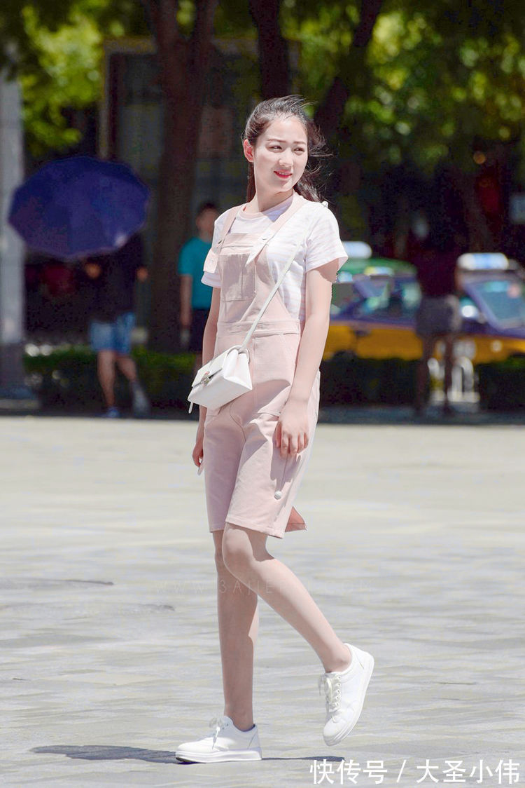 背带|美女街拍:粉色的背带连衣裙,内搭浅条纹的T恤,清新自然的穿搭很迷人