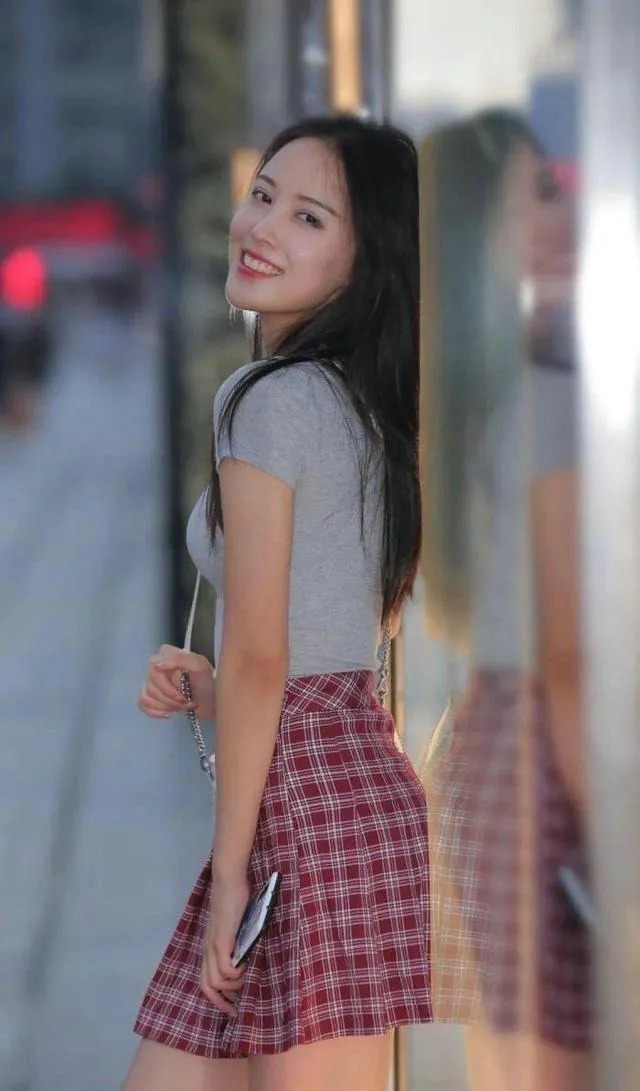 美女 美女穿灰色上衣搭配格子短裙,休闲质感扑面