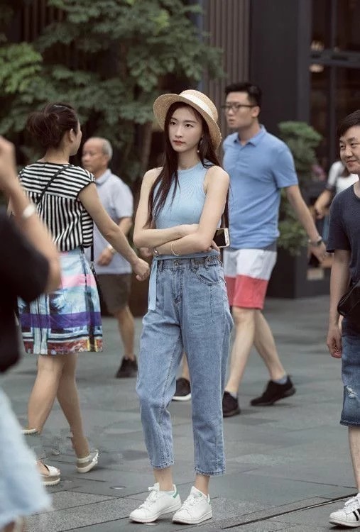 牛仔裤|街拍:紧身上衣配牛仔裤,美女戴一顶帽子,休闲又时尚