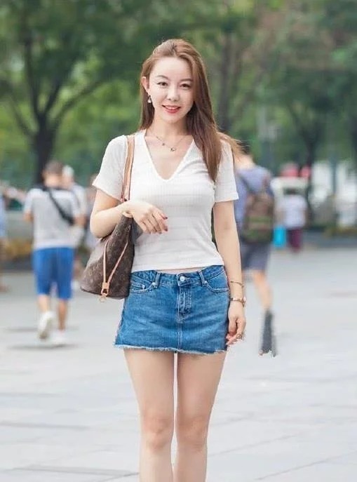 街拍:身穿黑色吊带衫的小美女,搭配白色鱼尾裙,尽显女人的魅力