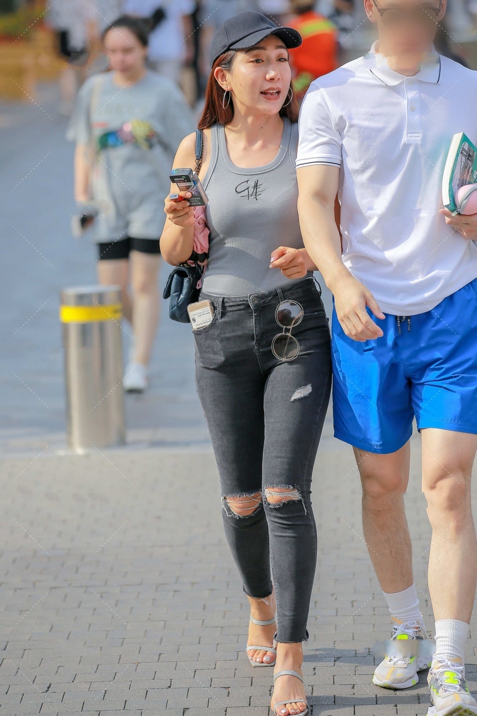 鸭舌帽|大姐姐身穿灰色背心和带黑色牛仔裤,加上黑色的鸭舌帽,很时尚