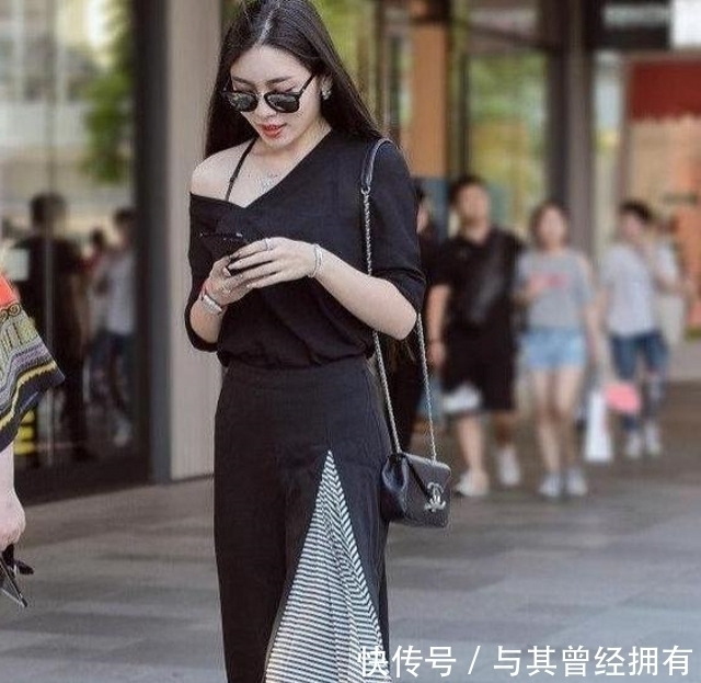 路人街拍，小姐姐穿一身黑色的时尚连衣裙，简洁的裁剪更显女人味