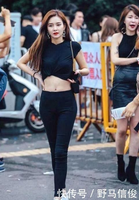 街拍小姐姐半袖上衣搭配黑色的短款下装,非常时尚具有美感