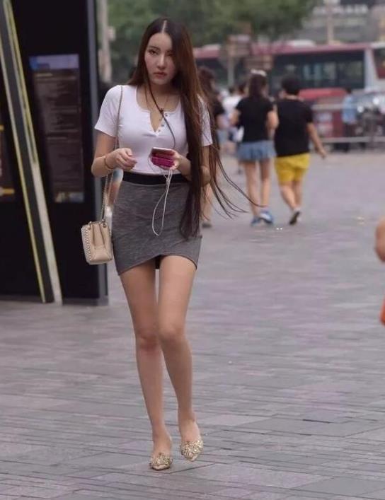 街拍:专注手机的小姐姐,身穿灰色连衣裙,超有范