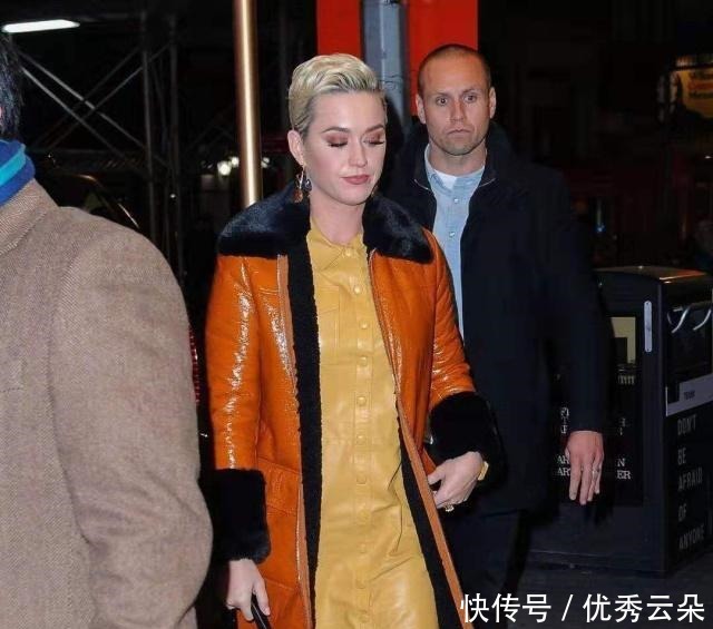 黄色皮裙上面套橙色皮风衣,这种时尚原谅我不懂,这是什么情况