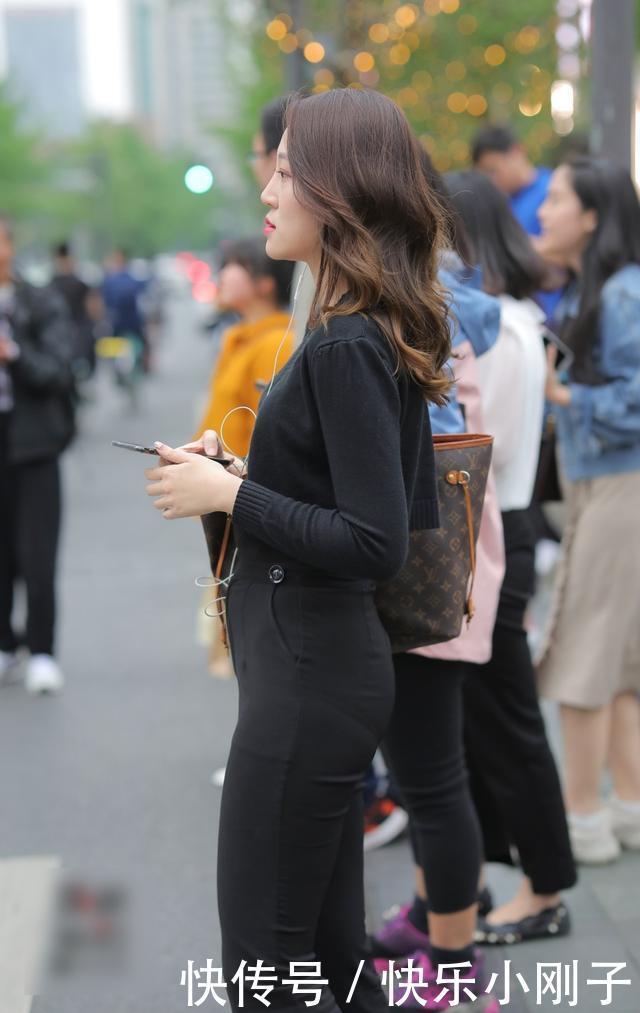 黑色的紧身T恤,搭配黑色喇叭裤,凸显出十足的女人味