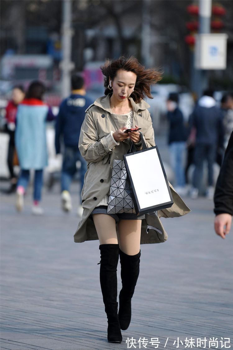 牛仔裤 街拍:美女搭配高腰牛仔裤,白色的尖头高跟短靴,更显身材高挑!