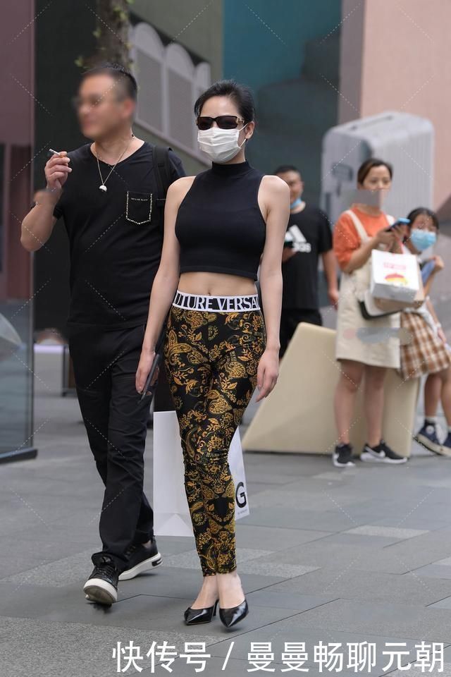 阿姨黑色半高领上衣搭配花纹修身裤,设计精美,尽显时髦气息