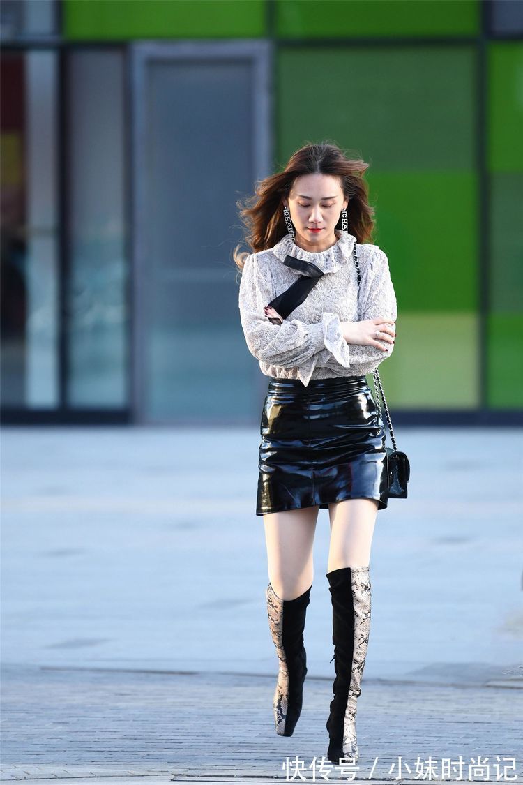 美女 街拍:美女高腰的黑色漆皮短裙,搭配拼接色的过膝靴,非常洋气!