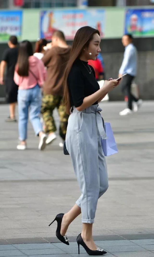 美女脚上搭配一双黑色尖头高跟鞋，让她整体搭配显得既优雅又时尚